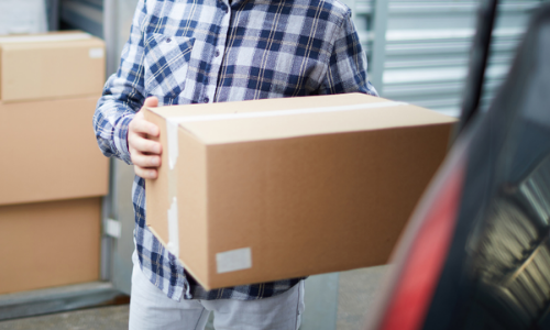 Man putting box in car